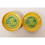 A pair of Chinese porcelain saucers, decorated with dragons and fruiting vines in the Sancai
