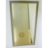 A bevelled glass wall mirror in decorative faux bois frame, 29" x 52½" overall