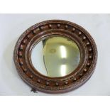 A C19th convex glass wall mirror in plaster frame, embellished with ball finials, 25" diameter