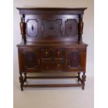 A Victorian Jacobean style sideboard with carved frieze and panelled upper section over two
