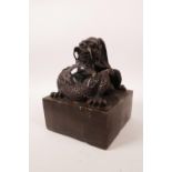 A large Chinese filled bronze seal of square form with a dragon knop, 5" x 5"