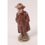 An antique pottery whistle in the form of a whistling man with his hands in pockets, 3" high