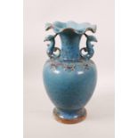 A Chinese two handled pottery vase with a frilled rim, and a turquoise and ochre splash glaze,