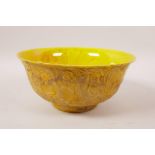 A yellow ground porcelain bowl with raised dragon decoration, 6 character mark to base, 6½" diameter