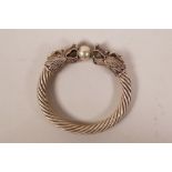 A Chinese white metal rope twist bangle with double dragon head decoration, 3½" diameter