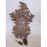 A C19th Black Forest wall cuckoo clock, with carved and pierced top, pendulum and core weights, with