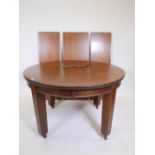 An early C20th mahogany wind out dining table with three leaves, 49" diameter, 96" extended