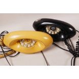 Two retro 'Genie' telephones, one peach and one black, 9" long