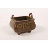 A Chinese bronzed metal censer with two handles and calligraphy decoration, character mark to