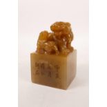 A Chinese soapstone square form seal with carved kylin decoration and character inscription, 2" x 2"