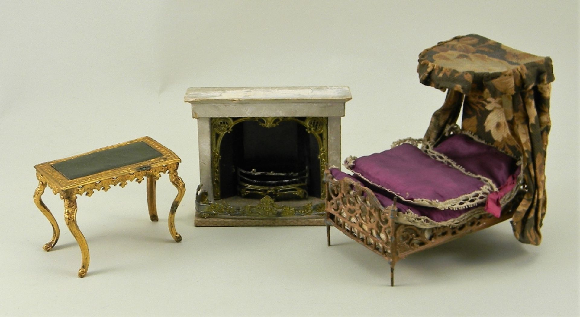 Dolls house fireplace, half tester bed and gilt metal table, 1880-90s,