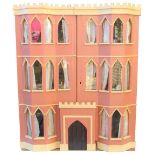 English painted pink wooden dolls house in the Gothic style,