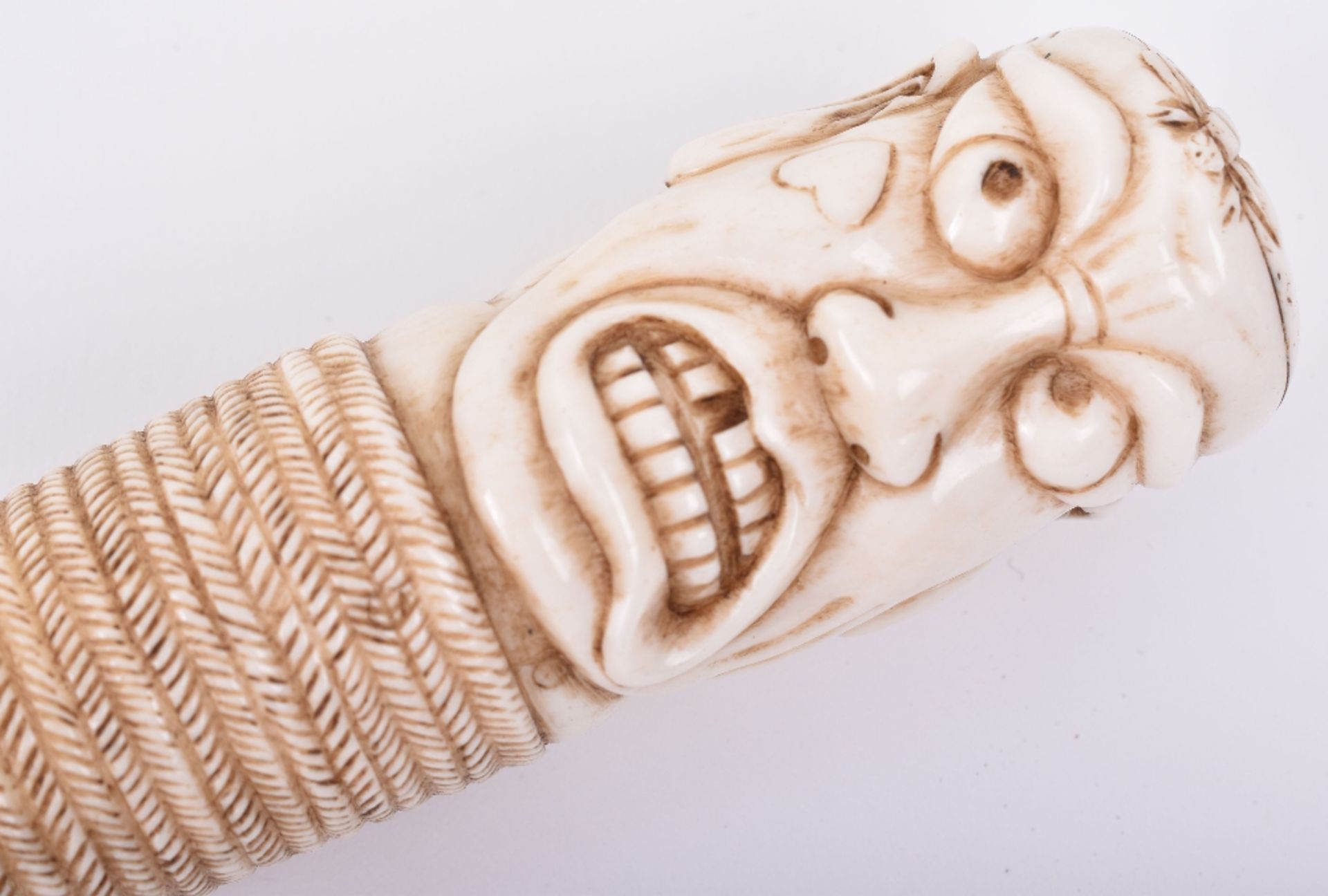 ^An early 20th century Japanese Okimono walking stick with carved ivory head