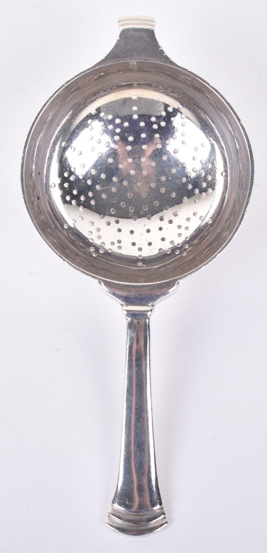 An Art Deco silver tea strainer, by Edward Barnard & Sons, London 1945