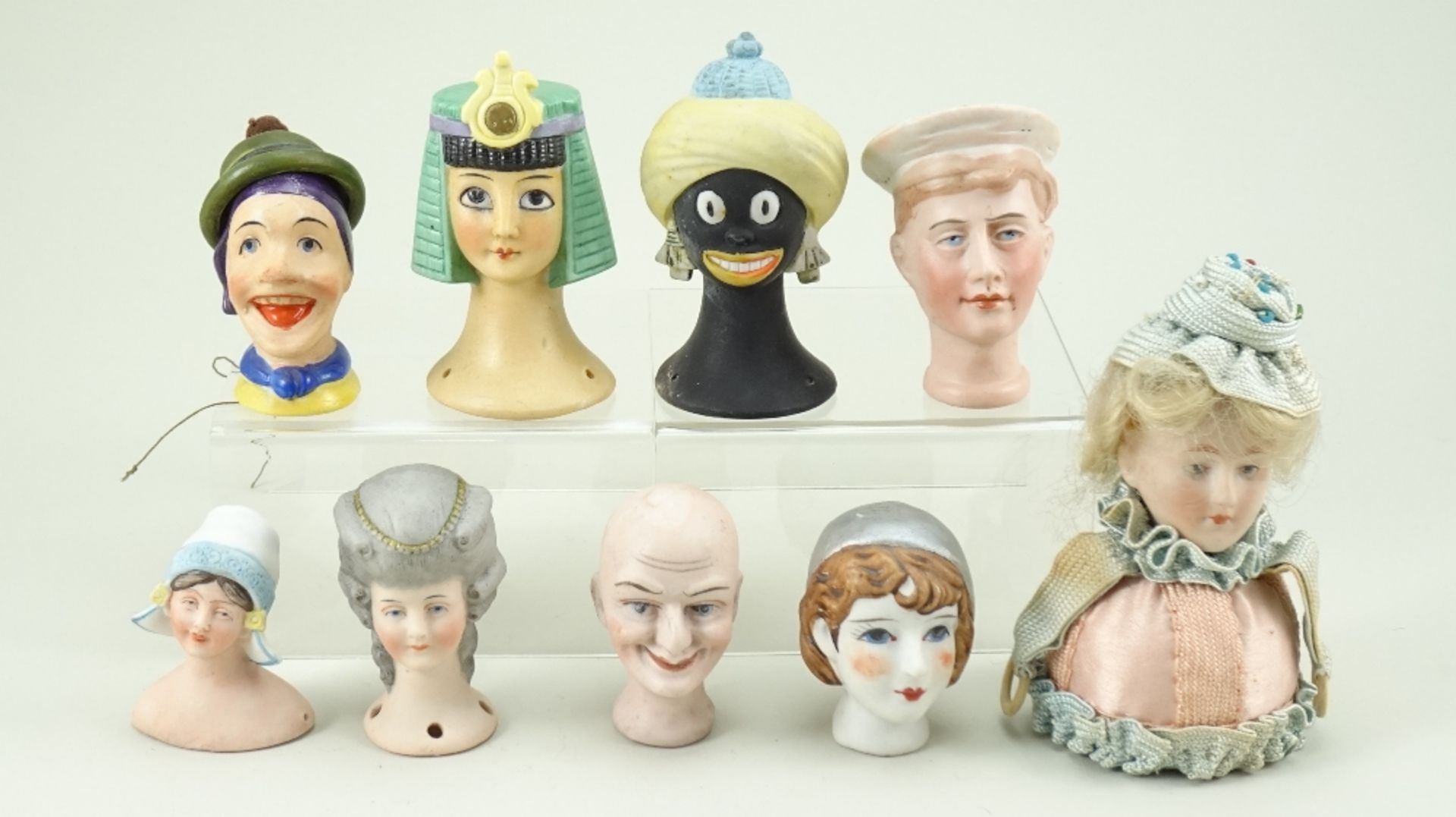 Nine bisque pin-cushion heads, 1920s,