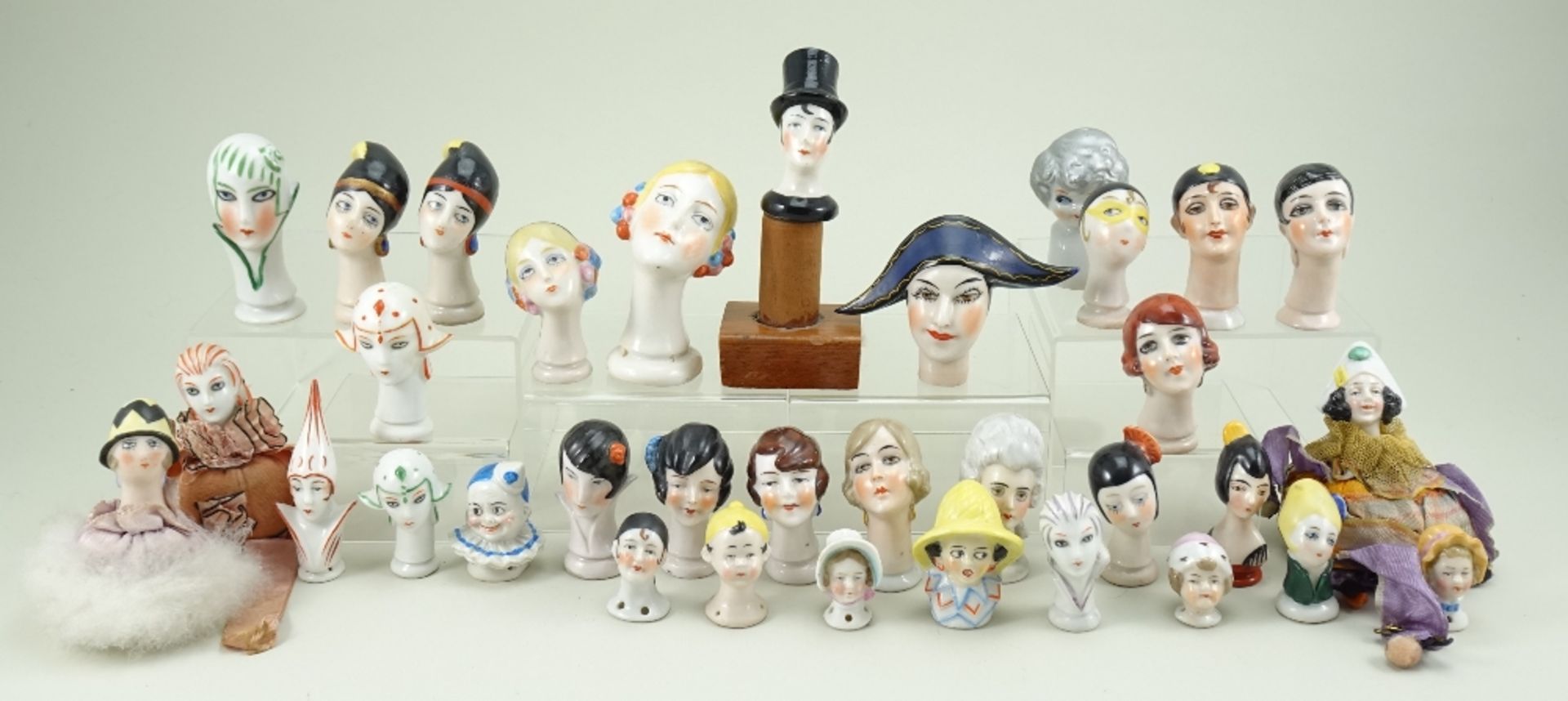 Collection of glazed china heads, 1920s,