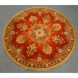 Circular red ground Persian rug, central medallion with scrolling decoration,