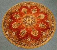 Circular red ground Persian rug, central medallion with scrolling decoration,