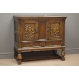 18th century style carved cupboard, two doors with coat of arms carvings above two drawers,