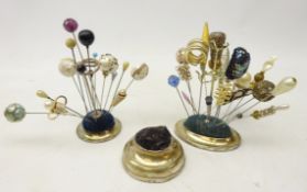 Two silver-plated hat pin stands, one centred with thistle finial,