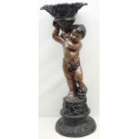 Victorian style jardiniere stand in the form of a cherub, holding a cornucopia shaped vase,