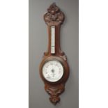 Early 20th century carved oak cased aneroid barometer with thermometer,