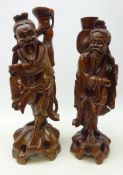 Large matched pair of Chinese hardwood figures each carved from the solid as a fisherman with inset