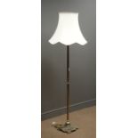 Cast metal standard lamp, reeded column, moulded base with paw feet, cream shade,
