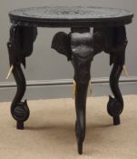 Anglo-Indian hardwood occasional table, black finish, heavily carved top and elephant supports,