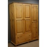 Pine triple combination wardrobe, three doors enclosing hanging rails, two drawers,
