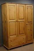 Pine triple combination wardrobe, three doors enclosing hanging rails, two drawers,