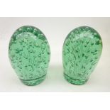 Two Victorian green glass dumpy weights each with multiple bubble inclusions,
