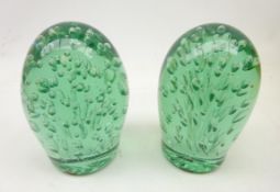 Two Victorian green glass dumpy weights each with multiple bubble inclusions,