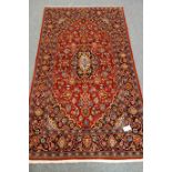Persian red ground rug, blue border, central medallion,