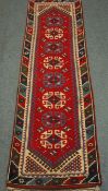 Turkish red ground runner rug with repeating geometric motif,