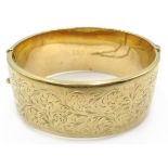 9ct gold hinged bangle, engraved leaf design approx 37.