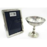 Silver pedestal bon-bon basket, weighted ht 10cm and a photograph frame ht 15cm both hallmarked