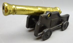 Cast metal desk model of a 1790 Naval canon with brass barrel on black four wheeled carriage,