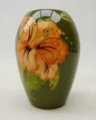 Moorcroft 'Hibiscus' pattern baluster shaped vase on green ground,