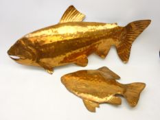 Two copper fish shaped decorative wall hangings depicting a salmon and bream,