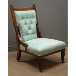 Edwardian oak framed nursing chair, upholstered in a teal fabric with floral pattern,