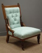 Edwardian oak framed nursing chair, upholstered in a teal fabric with floral pattern,