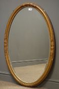 20th century mirror in gilt oval frame, bevelled glass plate, W68cm,