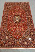 Persian red ground rug, blue border, central medallion,