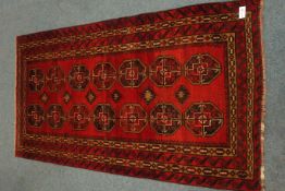 Antique Persian Bokhara red ground rug,
