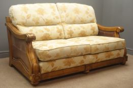 Hardwood framed bergere two seat sofa, upholstered in a gold floral fabric with leather side panels,