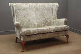 Mid 20th century Parker Knoll two seat wing back sofa upholstered in a grey fabric with a floral