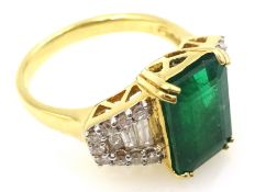 18ct gold emerald ring, with tapered baguette and round brilliant cut diamonds either side,