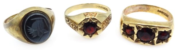 Two 9ct gold gentleman's garnet set rings and an onyx signet ring all hallmarked