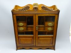 Large early 20th century oak smokers cabinet with two, part glazed panel doors and fitted interior,